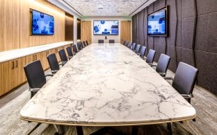 Board room with a long table and multiple chairs on each side. 